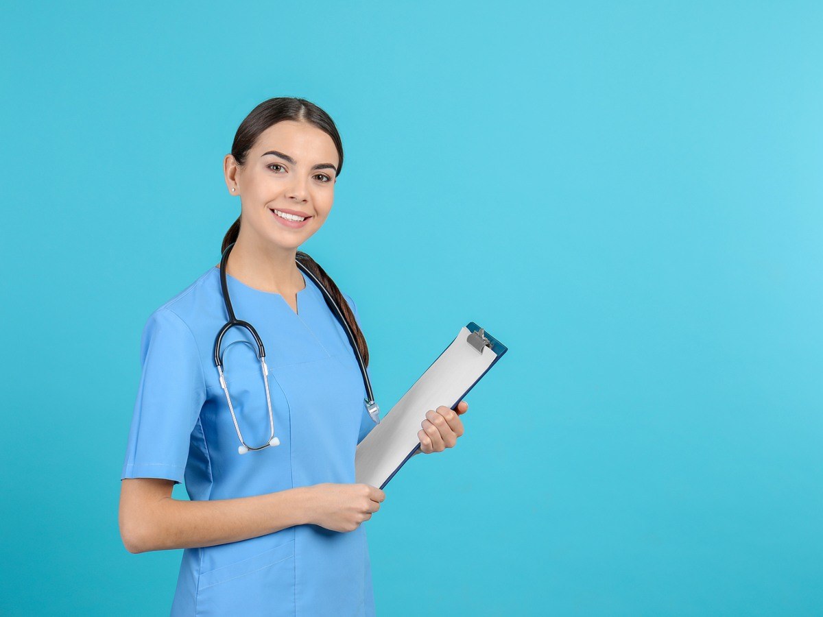 Smiling BSN student in Maryland standing and holding a clipboard.