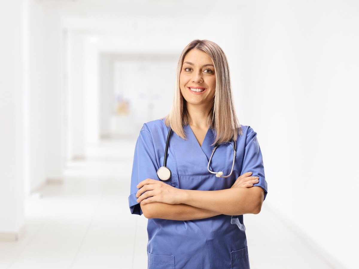 Nursing student in scrubs standing in a hallway at a nursing school in Indianapolis.