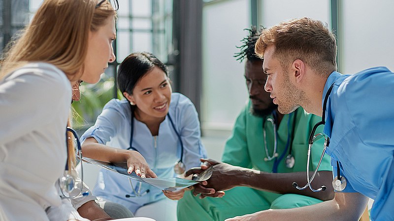 Four nurses sitting together and reviewing a document in a BSN to MSN program.