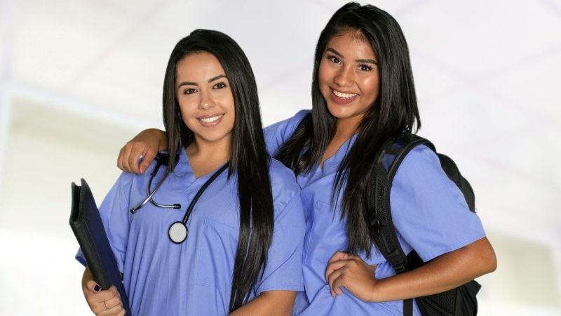 Two nursing students smiling and supporting each other in one of the fastest MSN programs.