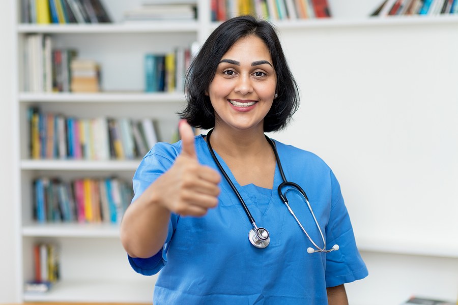 Nurse smiling with a thumbs up enrolled in a DNP program in Texas.