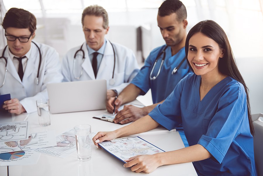 A group of nurses sitting at a table working on coursework in a DNP program in New Jersey.