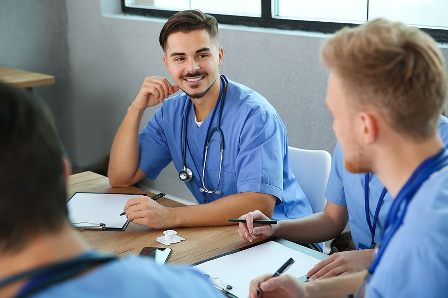 nurses within a DNP program in Massachusetts sitting at a table and discussing coursework.