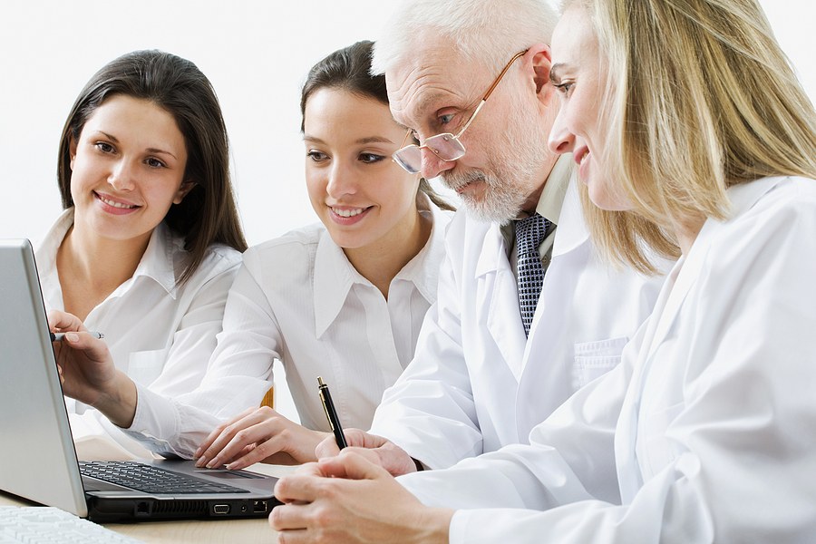 Group of nursing students reviewing coursework on a laptop while enrolled in a Nurse Educator program in New Jersey.