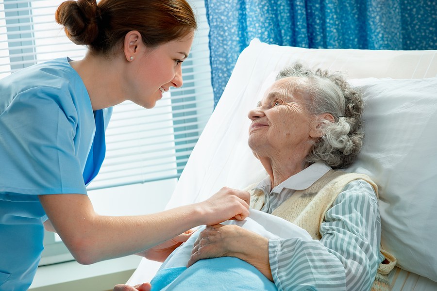 A medical assistant student in Alabama provides bedside care to an elderly patient during clinical training.
