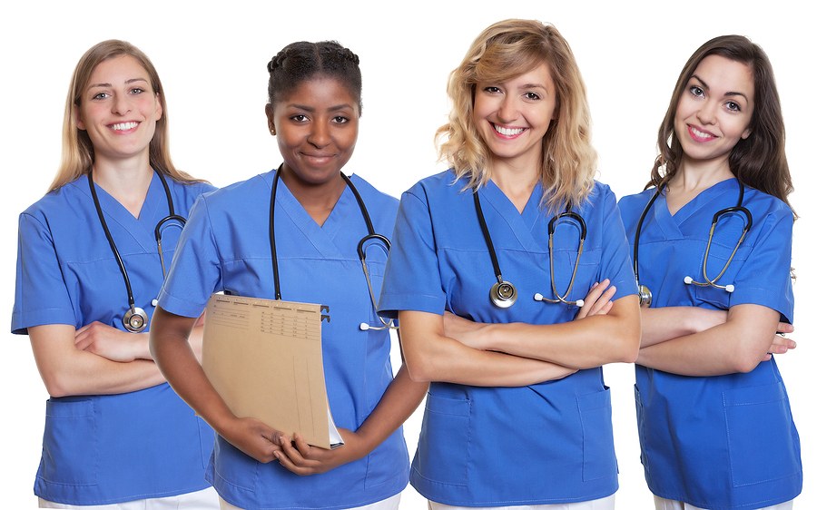 Group of nursing students in blue scrubs posing together at one of the best nursing schools in Iowa.