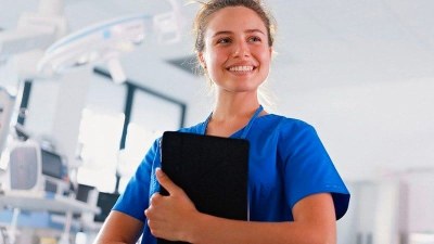 2. Nurse in scrubs holding a clipboard during clinical training for a BSN to DNP program