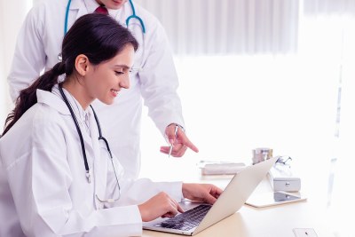 Two nurses viewing Nurse Educator coursework on a laptop in a program in Michigan.