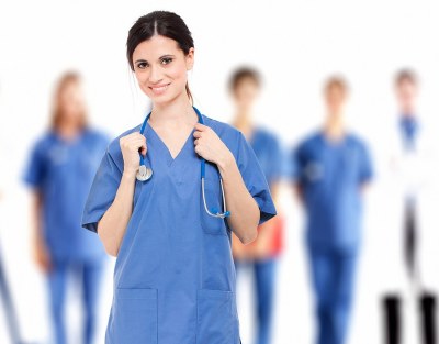 Nurse smiling holding a stethoscope around her neck studying in an MSN program in New York.