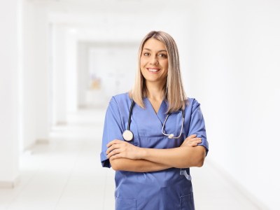 Nursing student in scrubs standing in a hallway at a nursing school in Indianapolis.