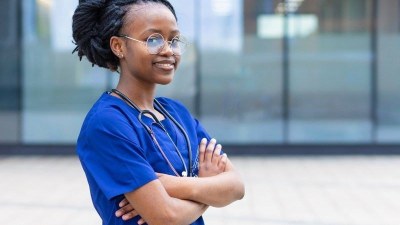 Nursing student standing outside in scrubs with stethoscope at a nursing school in Philadelphia.