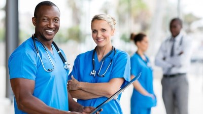 Two medical assistant students in scrubs smiling during clinical training at a healthcare facility in Pennsylvania.