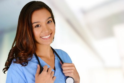 Nurse in scrubs smiling standing in a nursing school in Minnesota.