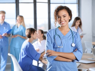 Nursing student in a Columbus, Ohio school standing with their arms crossed.