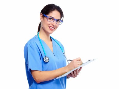Nursing student in scrubs taking notes while preparing for clinicals in one of the best ADN programs in Maryland.
