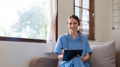 Medical assistant student in Georgia studying with a tablet in a bright room.