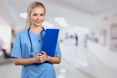 Nursing student holding a clipboard in a clinical hallway, representing nursing programs in Indiana.