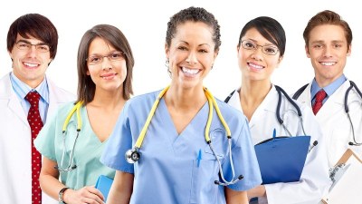Healthcare students standing and smiling while enrolled in a DNP program in California.