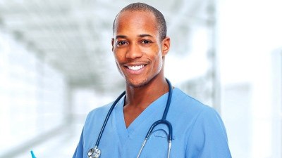 Smiling nurse in scrubs enrolled in a dual DNP/PhD program
