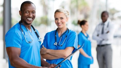 Nurse practitioner students in Massachusetts smiling in a clinical setting during graduate NP training.