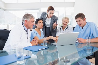 A group of nurses sitting around a laptop in an MSN program in Colorado.