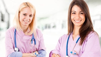 Nurse practitioner students in New Jersey wearing scrubs and studying together in a clinical education setting.