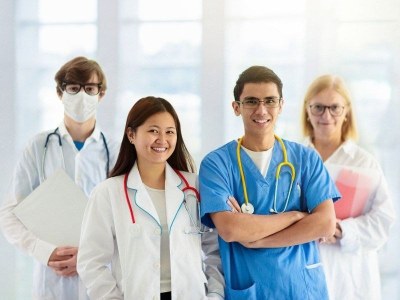 Four smiling nurses standing together after graduating from one of the fastest BSN programs.